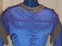 Very detailed view of front, showing braided self fabric trim and handmade buttonholes.